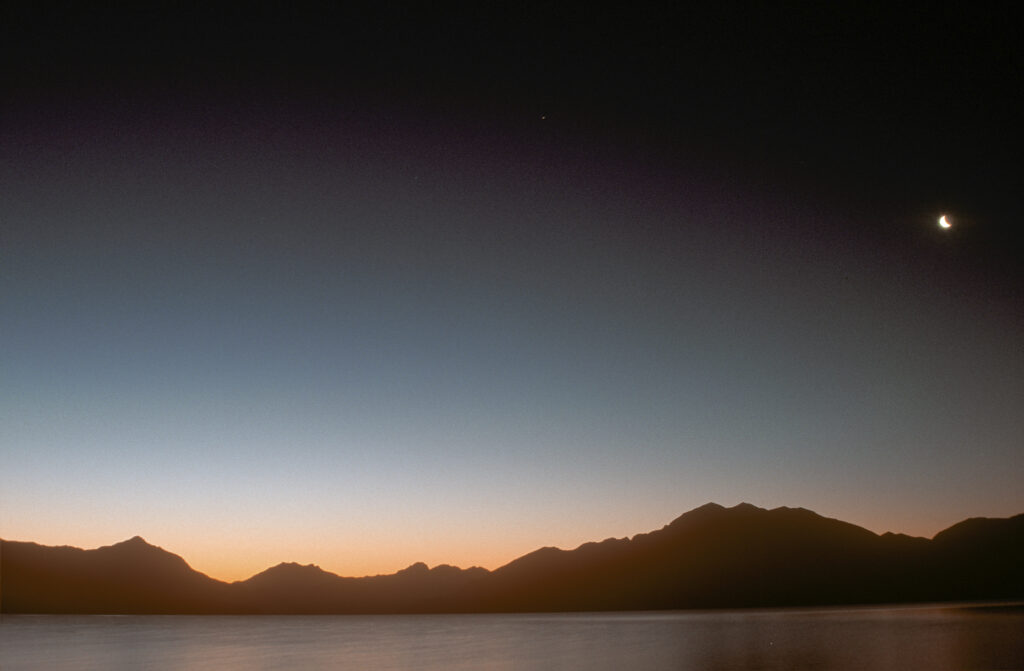 NEW ZEALAND, Southland, Lake Te Anau. Dusk overlooking the lake towards the mountainous peaks of Fiordland National Park