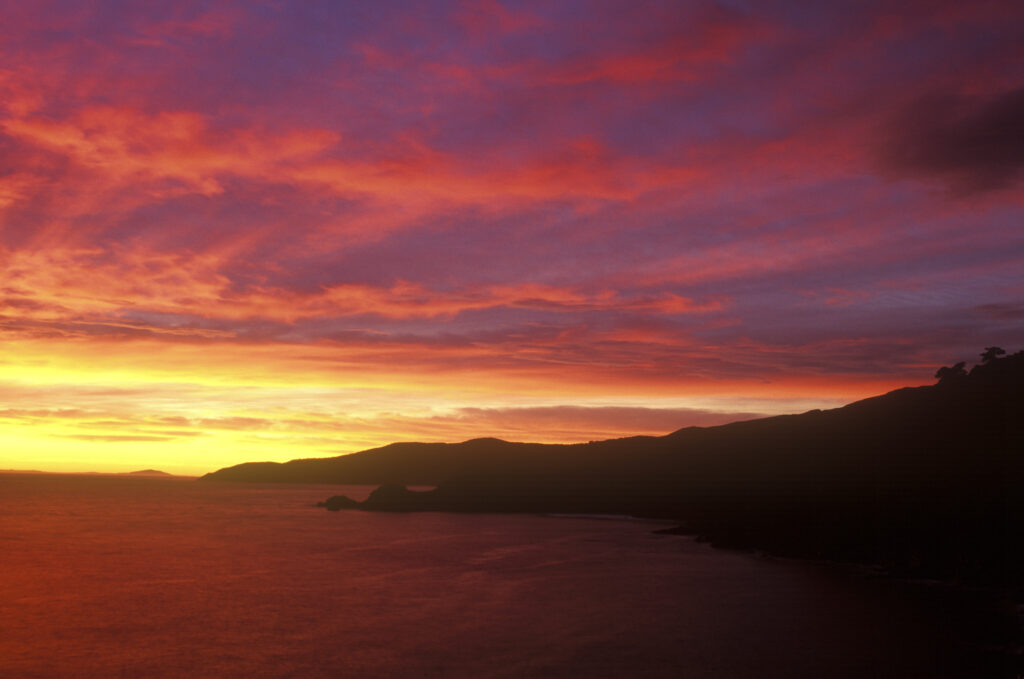 NEW ZEALAND, Stewart Island, Long Harry. A spectacular sunrise over the waters surrounding the Rakiura national park