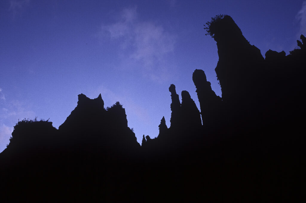 NEW ZEALAND, North Island, Putangirua Pinnacles. The impressive form of the monoliths Silhouetted against a blue sky