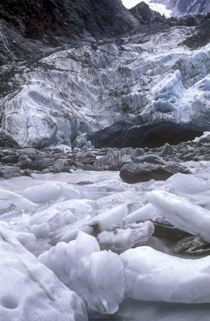 NEW ZEALAND, West Coast, Westland National Park. Huge deposited rocks and ice in the river formed from the Franz Josef Glacier