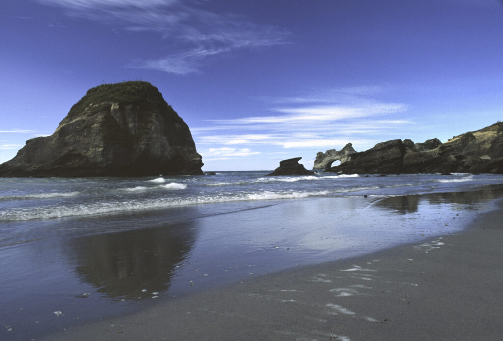 NEW ZEALAND, South Island, Whariki Beach & Sea Arch. The rugged coastline of this popular tourist beach