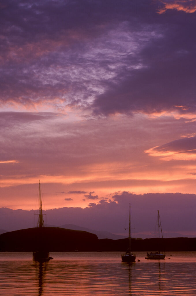 SCOTLAND, Scottish highlands, Oban. The pinks and reds of a west coast sunset looking towards the western isles.