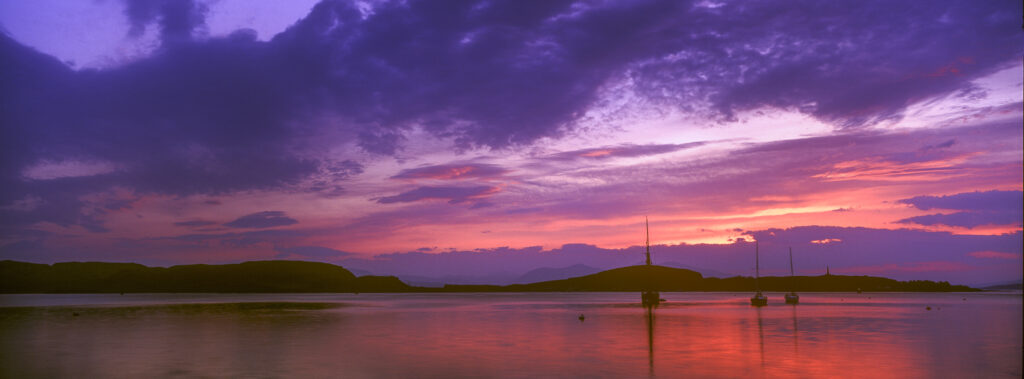 SCOTLAND, Scottish highlands, Oban. The pinks and reds of a west coast sunset looking towards the western isles.