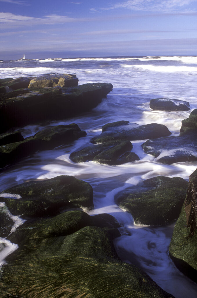 ENGLAND, Tyne & Wear, Whitley Bay. The north sea waves engulf the rocks of the town beach