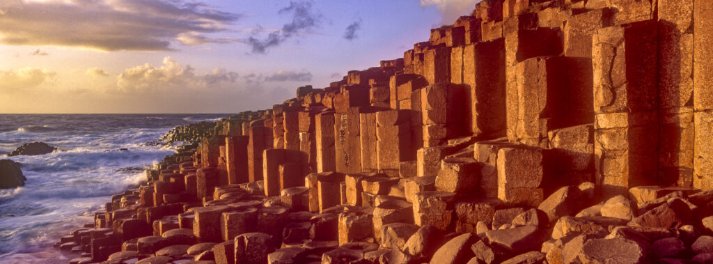 NORTHERN IRELAND, County Antrim, Giants Causeway. Waves crash against the hexagonal basalts rock formations of this world heritage site.