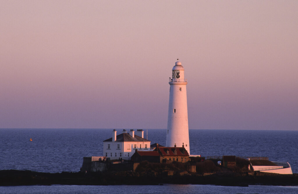 ENGLAND, Tyne & Wear, St Marys Island. The popular landmark of the lighthouse against a natural pink backdrop