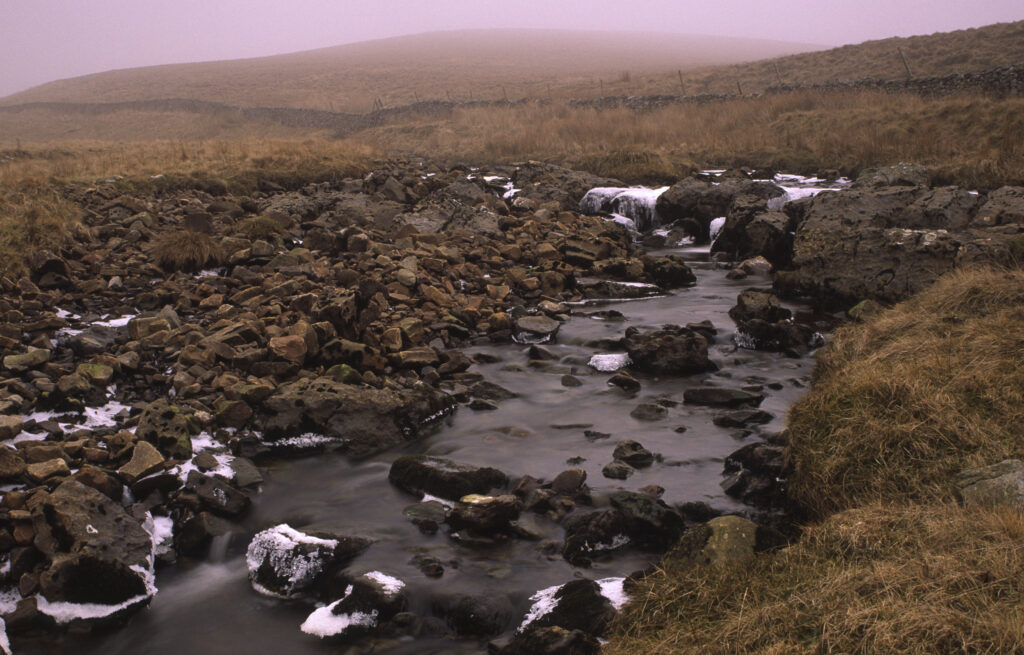ENGLAND, Yorkshire, Yorkshire Dales National Park. A stream flowing through the hills above horton in ribblesdale