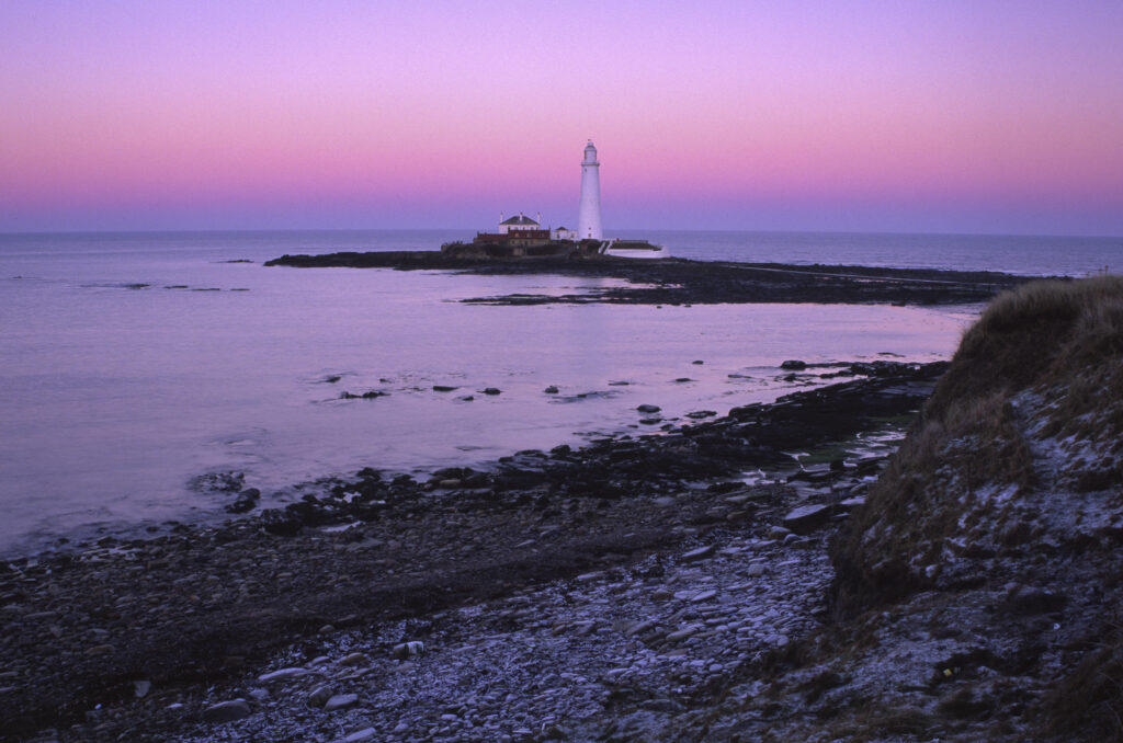 ENGLAND, Tyne & Wear, St Marys Island. The popular landmark of the lighthouse against a natural pink backdrop