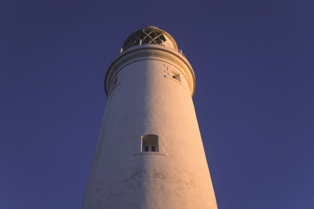 ENGLAND, Tyne & Wear, St Marys Island. Warm evening sun illuminates the popular whitley bay landmark of the lighthouse