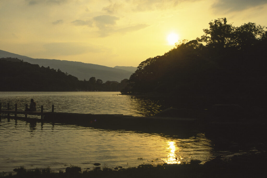 ENGLAND, Cumbria, Lake District National Park. A tranquil sunset over the waters of Derwentwater near Keswick.