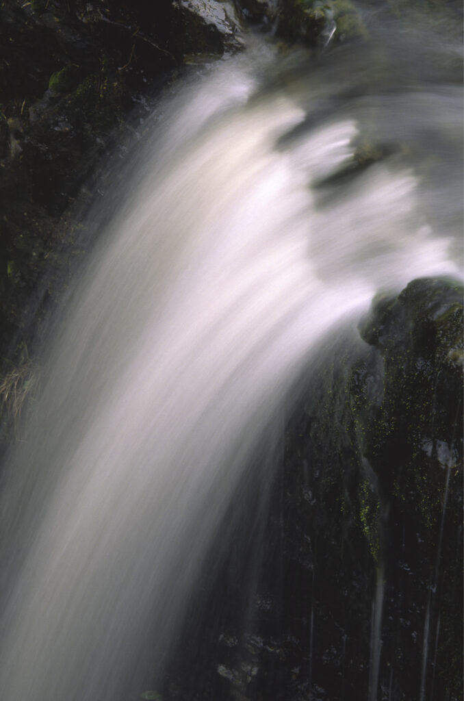 ENGLAND, Yorkshire, Yorkshire Dales National Park. A flowing stream drops into an underground cave system