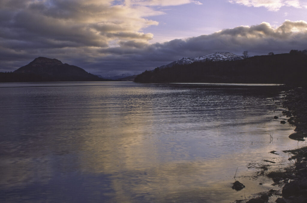 SCOTLAND, Scottish Highlands, Loch Laggan. A storm clears behind the peaks surrounding the still waters of the loch.