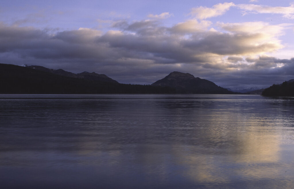 SCOTLAND, Scottish Highlands, Loch Laggan. A storm clears behind the peaks surrounding the still waters of the loch.