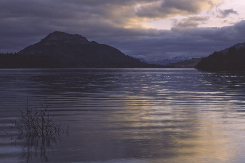 SCOTLAND, Scottish Highlands, Loch Laggan. A storm clears behind the peaks surrounding the still waters of the loch.