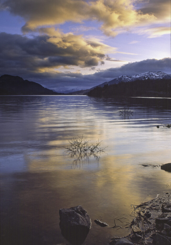 SCOTLAND, Scottish Highlands, Loch Laggan. A storm clears behind the peaks surrounding the still waters of the loch.