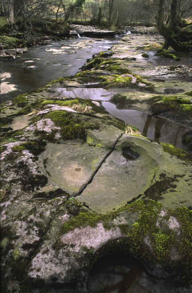 ENGLAND, Yorkshire, Yorkshire Dales National Park. The flowing waters and dry limestone river bed of the river Dee.