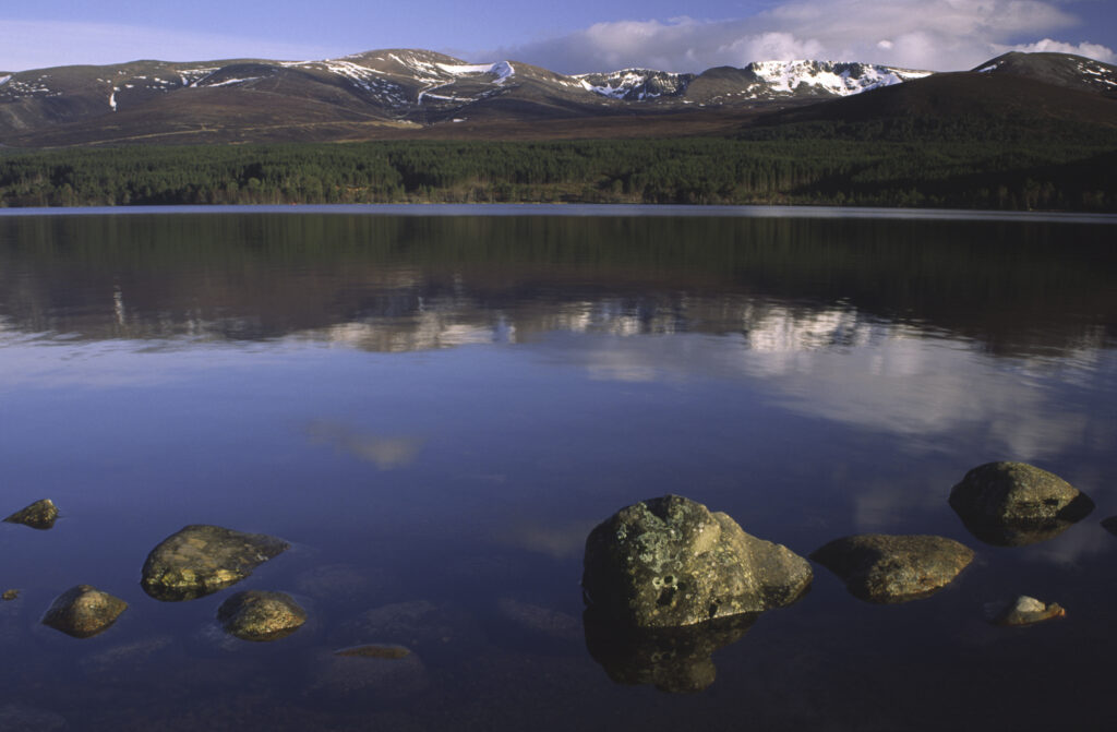 SCOTLAND, Scottish Highlands, Cairngorms National Park. The Cairngorm mountain range reflected in still waters of Loch Morlich