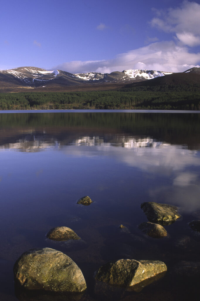 SCOTLAND, Scottish Highlands, Cairngorms National Park. The Cairngorm mountain range reflected in still waters of Loch Morlich