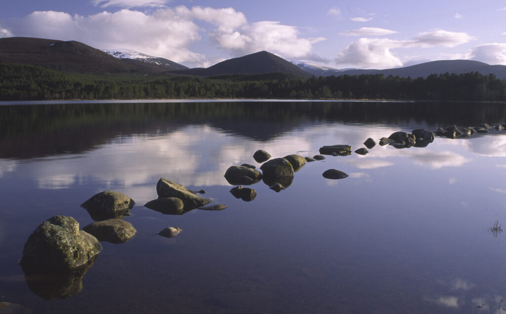 SCOTLAND, Scottish Highlands, Cairngorms National Park. The Cairngorm mountain range reflected in still waters of Loch Morlich
