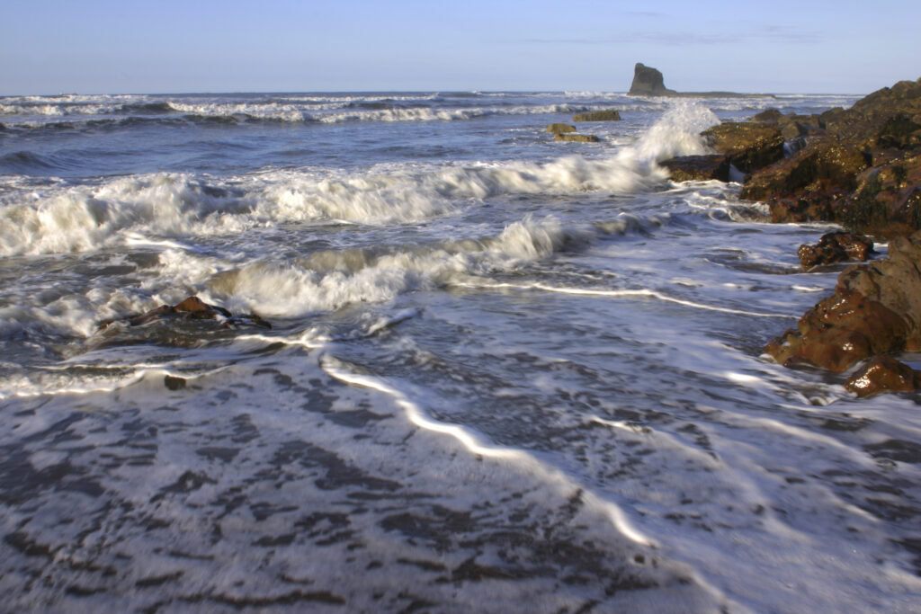 ENGLAND, Yorkshire, North York Moors National Park. Evening light iluminates the boulders and tide of Saltwick Bay near Whitby