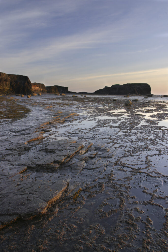 ENGLAND, Yorkshire, North York Moors National Park. Morning light iluminates the coastline of Saltwick Bay and Nab near Whitby