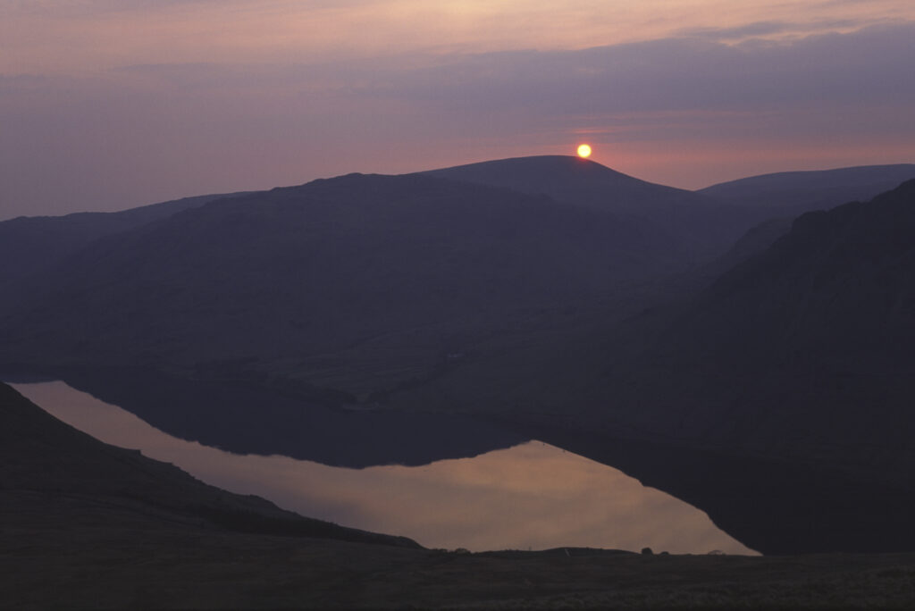 ENGLAND, Cumbria, Lake District National Park. Sunset reflected in the still waters of Wast Water Englands deepest lake