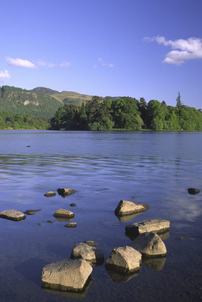 ENGLAND, Cumbria, Lake District National Park. The setting sun illuminates the lakeside and islands of Derwentwater nr Keswick