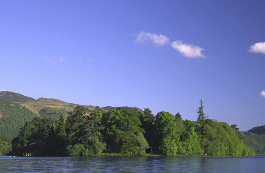 ENGLAND, Cumbria, Lake District National Park. The setting sun illuminates the lakeside and islands of Derwentwater nr Keswick