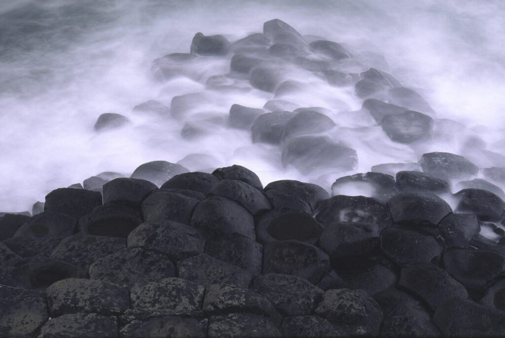 NORTHERN IRELAND, County Antrim, Giants Causeway. Waves crash against the hexagonal basalts rock formations of this world heritage site.