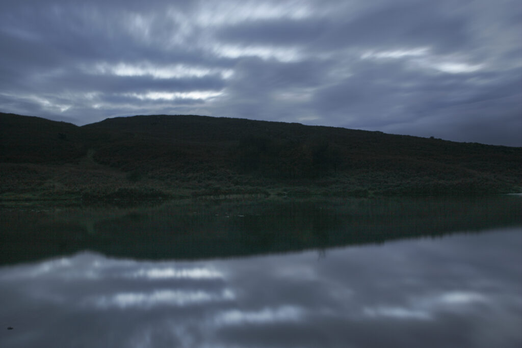 England, Cumbria, Lake District National Park. Cloud formations reflected in the still waters of Beacon Tarn on cumbria way