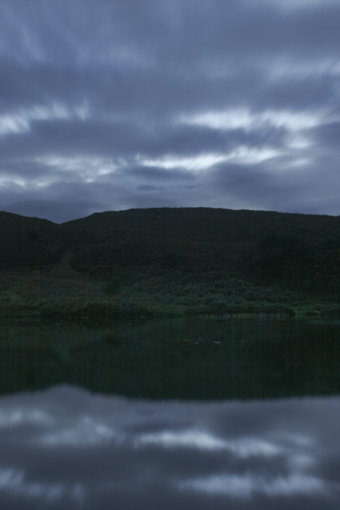 England, Cumbria, Lake District National Park. Cloud formations reflected in the still waters of Beacon Tarn on cumbria way