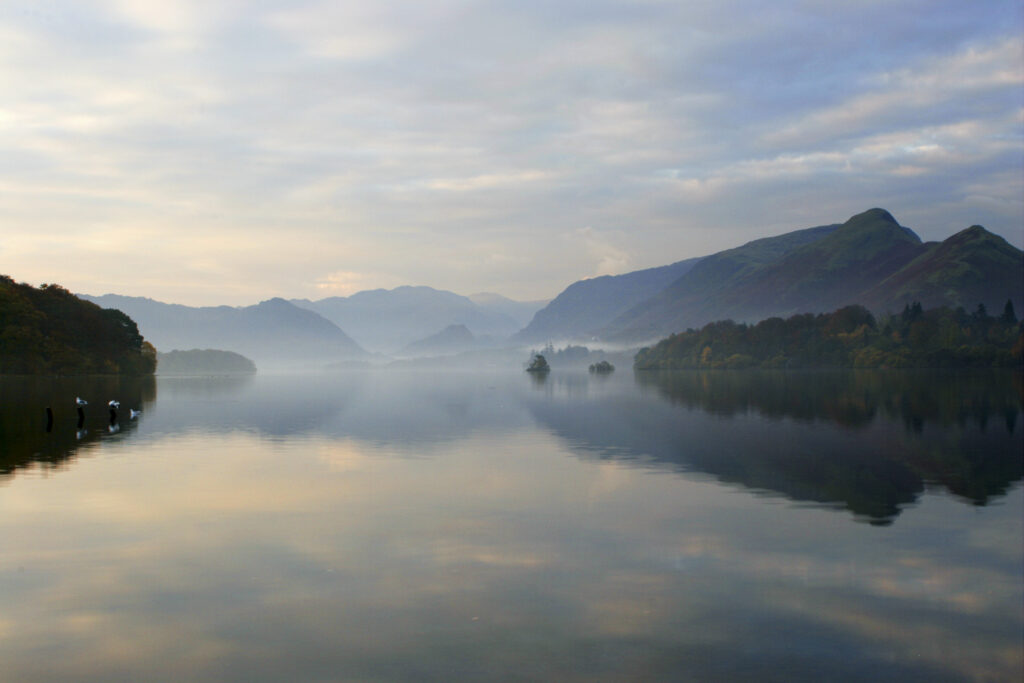 ENGLAND Cumbria Lake District National Park The pastel colours of dawn reflected in the still waters of Derwentwater