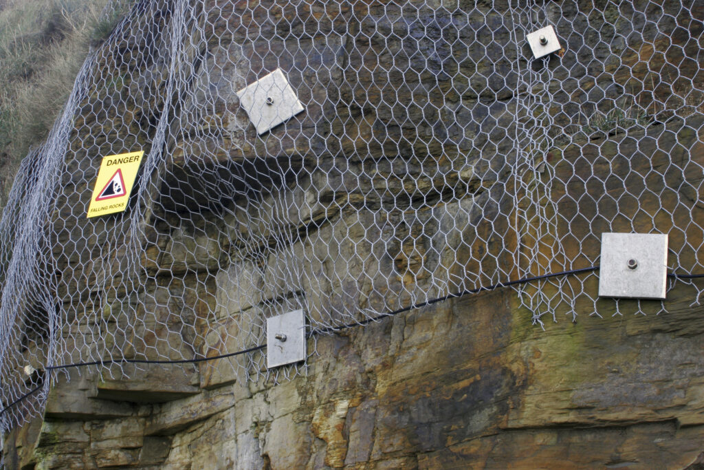 England, Tyne and wear, Whitley Bay. Wire mesh implemented to protect walkers from falling rocks along the north tyneside coast