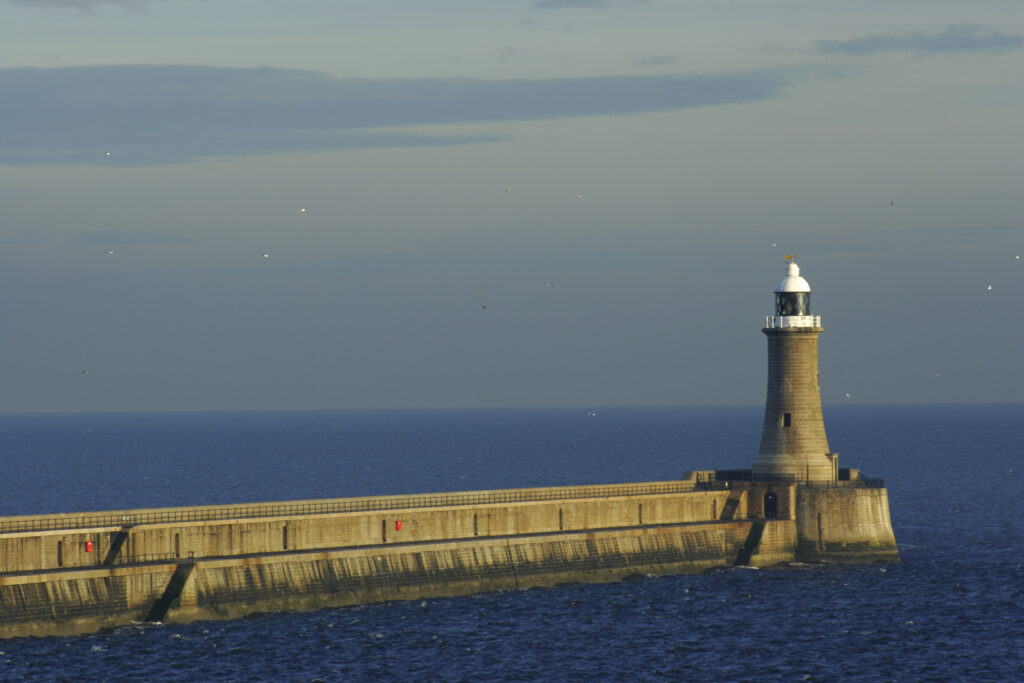ENGLAND, Tyne and Wear, Tynemouth. The north tyne pier lighthouse guides ships coming through the river Tyne from the north sea