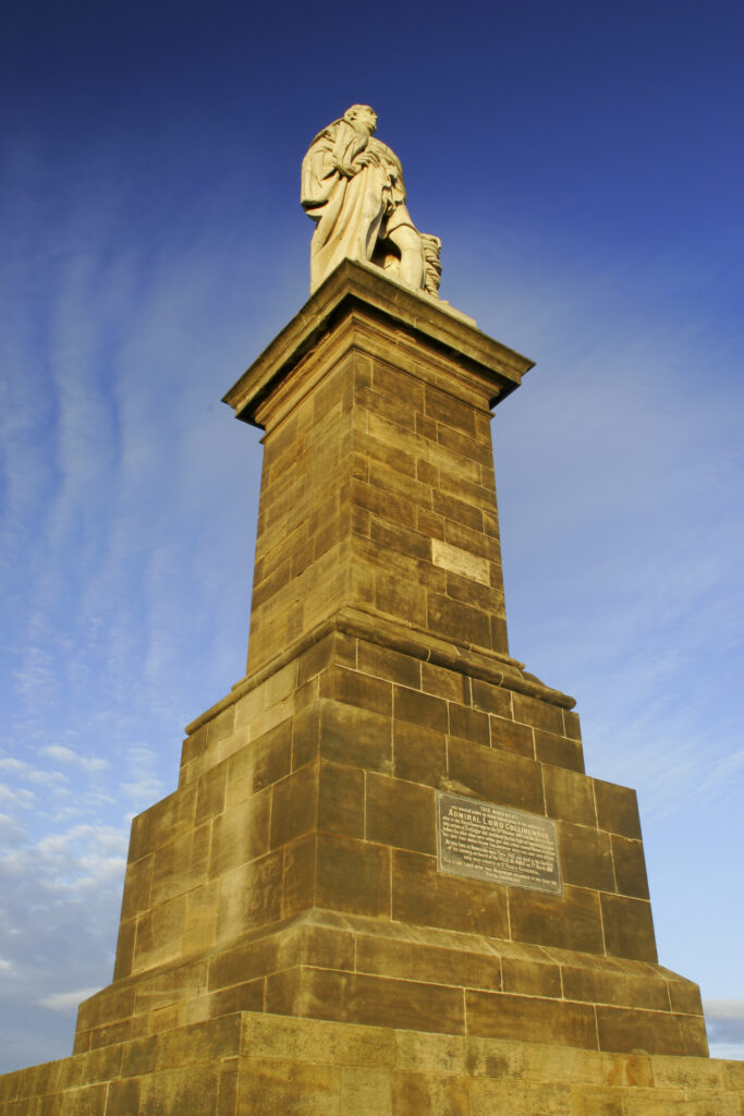 ENGLAND, Tyne and wear, Tynemouth. The setting sun iluminates the Collingwood monument and cannons