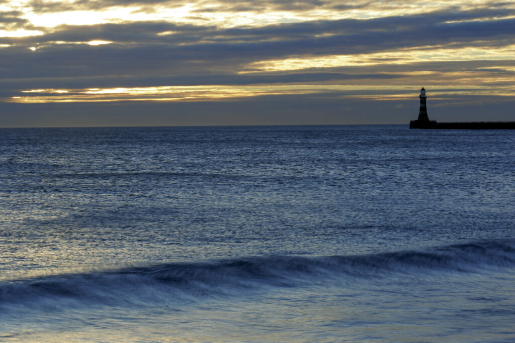 England, Tyne and Wear, Seaburn. Dawn looking across the North Sea towards the Roker pier and lighthouse