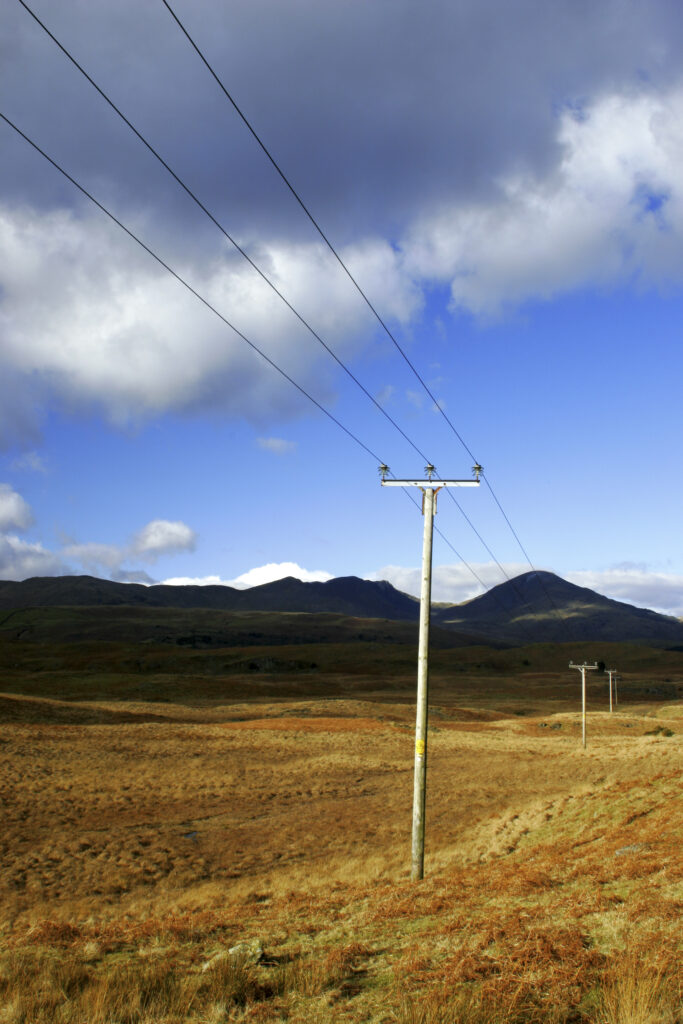 England, Cumbria, Lake District National Park. Power lines run across the remote landscape of Torver Common on the Cumbria Way