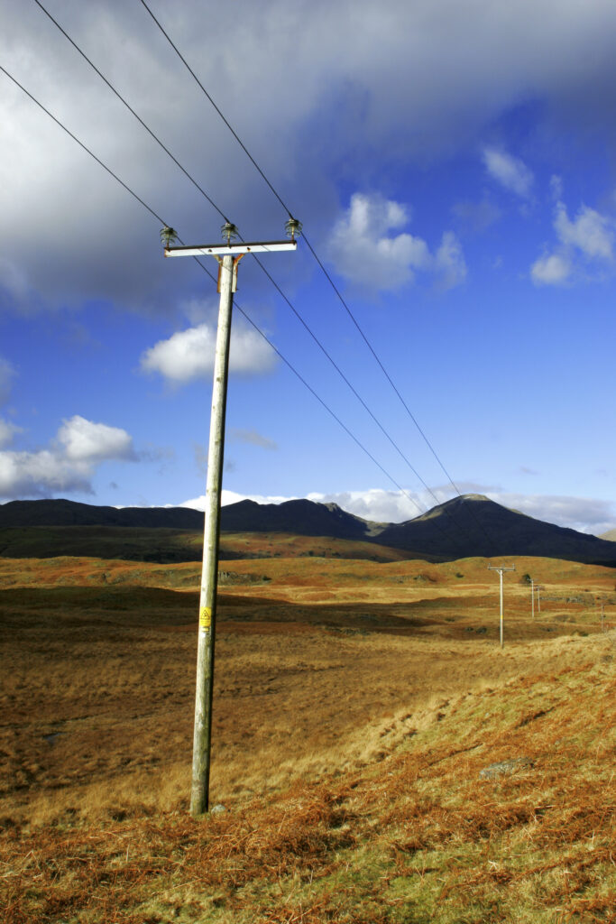England, Cumbria, Lake District National Park. Power lines run across the remote landscape of Torver Common on the Cumbria Way