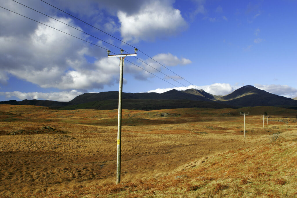 England, Cumbria, Lake District National Park. Power lines run across the remote landscape of Torver Common on the Cumbria Way