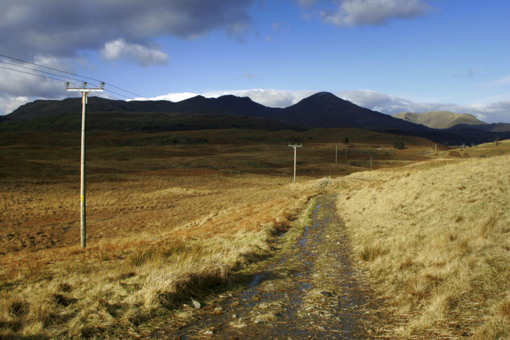 England, Cumbria, Lake District National Park. Power lines run across the remote landscape of Torver Common on the Cumbria Way