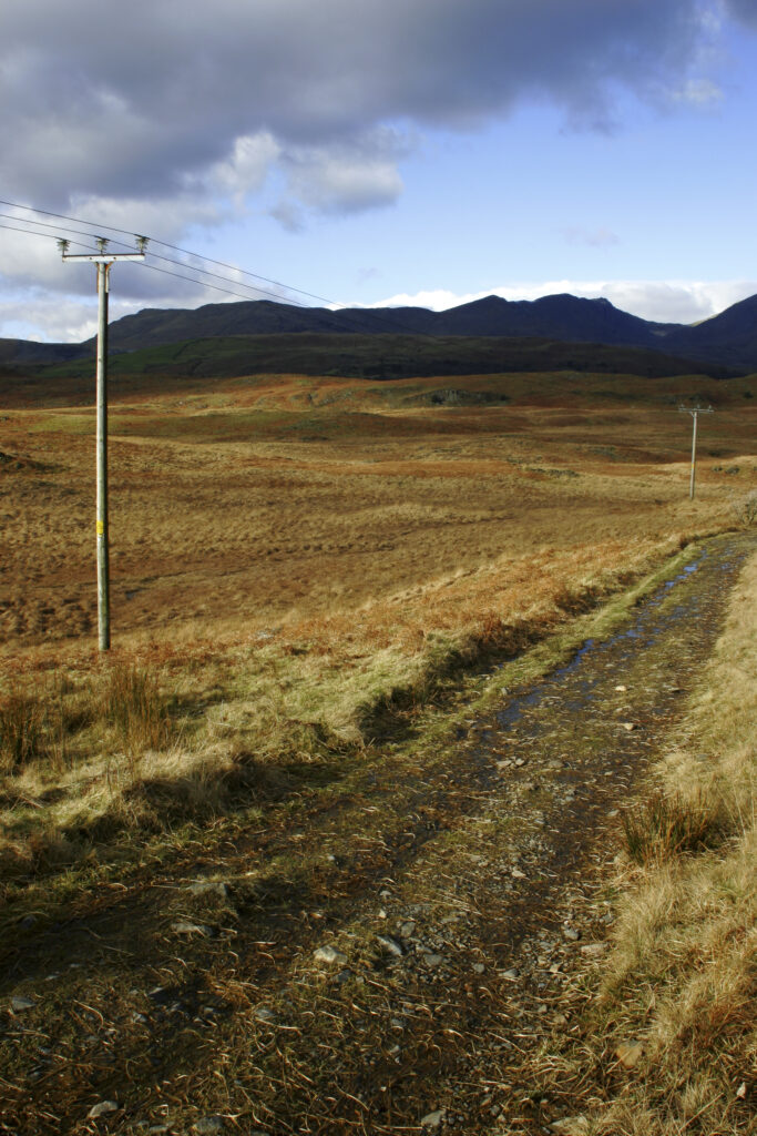 England, Cumbria, Lake District National Park. Power lines run across the remote landscape of Torver Common on the Cumbria Way