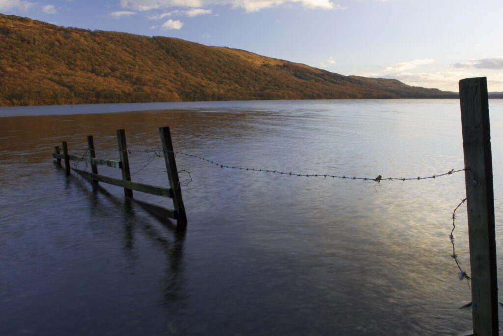 ENGLAND, Cumbria, Lake District National Park. Afternoon light illuminates the calm waters of Coniston Water on the Cumbria Way