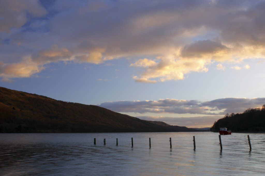 ENGLAND, Cumbria, Lake District National Park. Afternoon light illuminates the calm waters of Coniston Water on the Cumbria Way