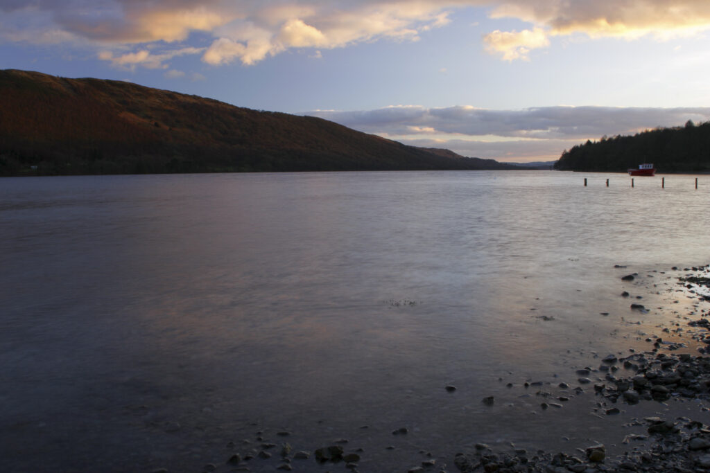 ENGLAND, Cumbria, Lake District National Park. Afternoon light illuminates the calm waters of Coniston Water on the Cumbria Way