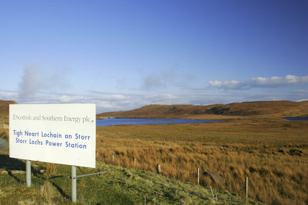 Scotland The Isle of Skye Loch Leathan Soft afternoon light illuminates Loch Leathan and Storr Lochs Power Station Sign, with surrounding moorland and hills