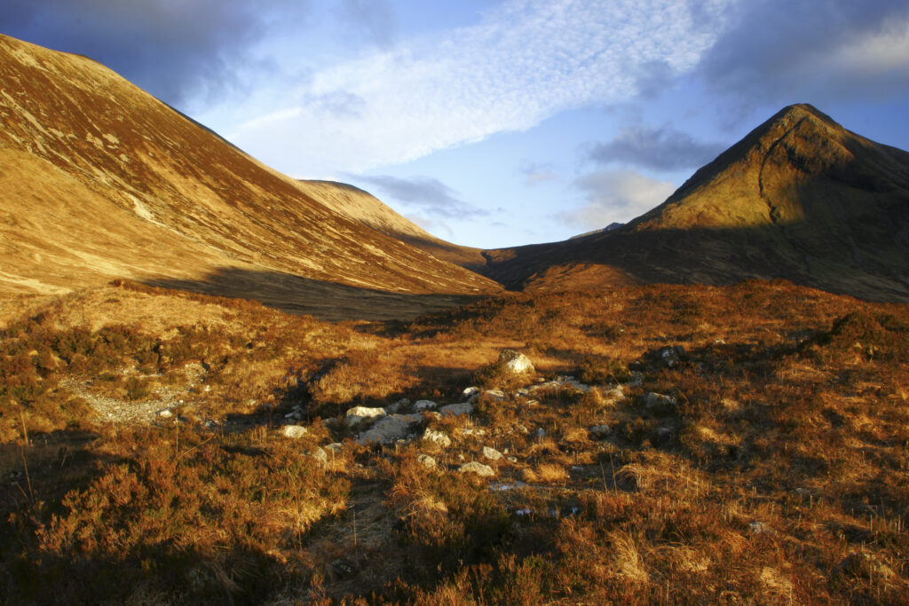 Scotland, Isle of Skye, Glen Sligachan. Evening light iluminates the red hues of the wild mountain landscape of Glen Sligachan