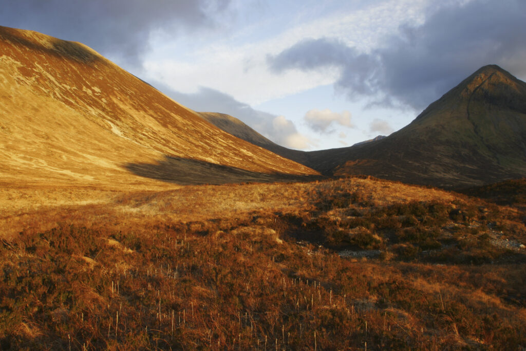 Scotland Isle of Skye Glen Sligachan Evening light iluminates the red hues of the wild mountain landscape of Glen Sligachan