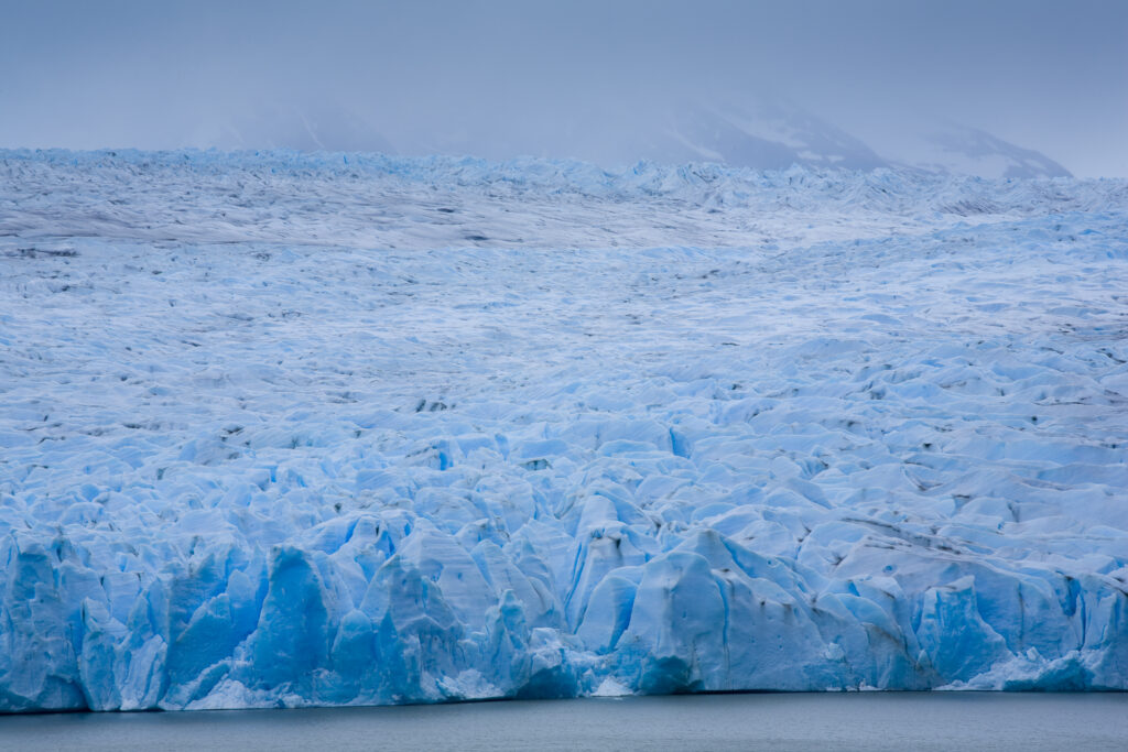 Chile, Southern Patagonia, Torres Del Paine National Park. A clearing storm reveals the Patagonian Ice Field and the Grey Glacier meeting the Lago Grey.