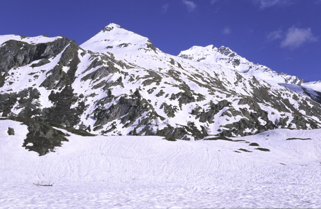 Italy, Valle d Aosta, Gran Paradiso National Park. Snow remains well into spring in the peaks of the landscape near Bardoney