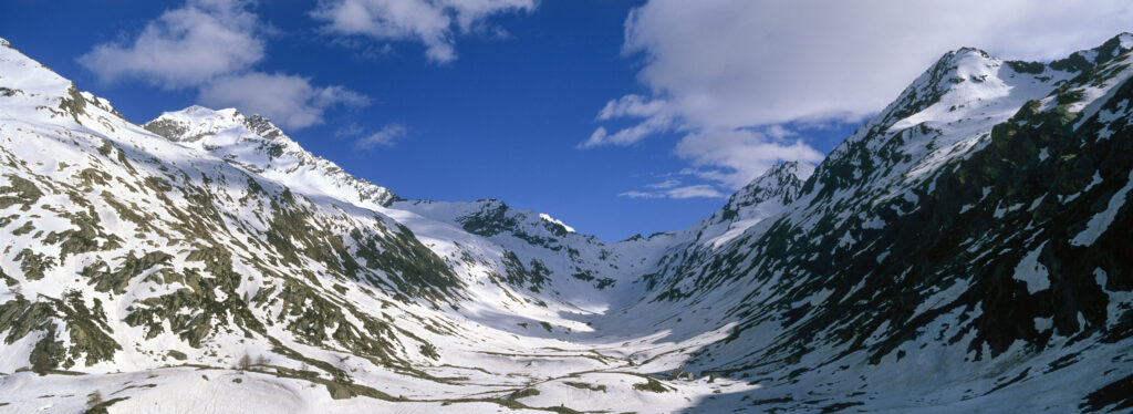 Italy, Valle d Aosta, Gran Paradiso National Park. Snow remains well into spring in the peaks of the landscape near Bardoney